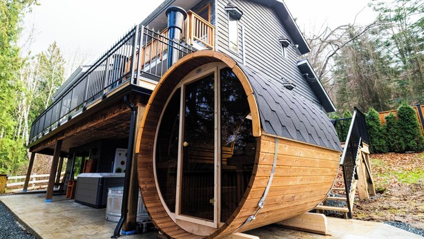 A modern house with a large circular window and a wooden deck.