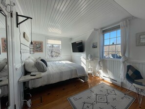 Cozy retreat with a large bed, bedside table, and flat-screen TV.