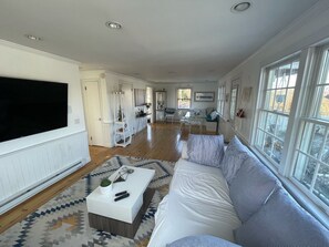 Relax in this stylish living area with a large flat-screen TV, comfortable seating, and a dining area.