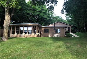 A two-story house with a covered patio and a separate garage. - Charming Cabin on Crystal-Clear Lake Latoka! (Alexandria)