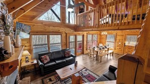 A spacious wooden cabin with a loft bedroom, a dining area, and a living room with a fireplace. - Pigeon Forge|Pool·Hot Tub|Game&Theater Rm·Pets·EV (Pigeon Forge)