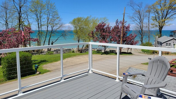 Une terrasse avec vue sur une plage et l’océan, une chaise et une table.