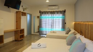 A hotel room with two beds, a flat-screen TV, an air conditioning unit, and a wooden shelf.