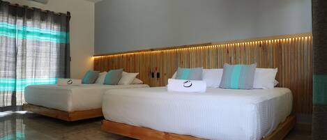 A modern hotel room with two beds, a wooden headboard, and a large window with curtains.