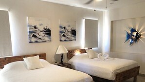 Two single beds with wooden frames and white bedding, a nightstand with a lamp, and artwork on the walls. - Casa Canto Del Mar (Fraccionamiento Nopolo, Loreto baja cali)