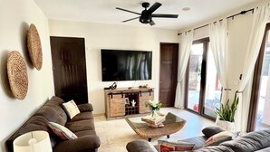A living room with a sofa, a coffee table, a TV, and a ceiling fan. - Casa Canto Del Mar (Fraccionamiento Nopolo, Loreto baja cali)