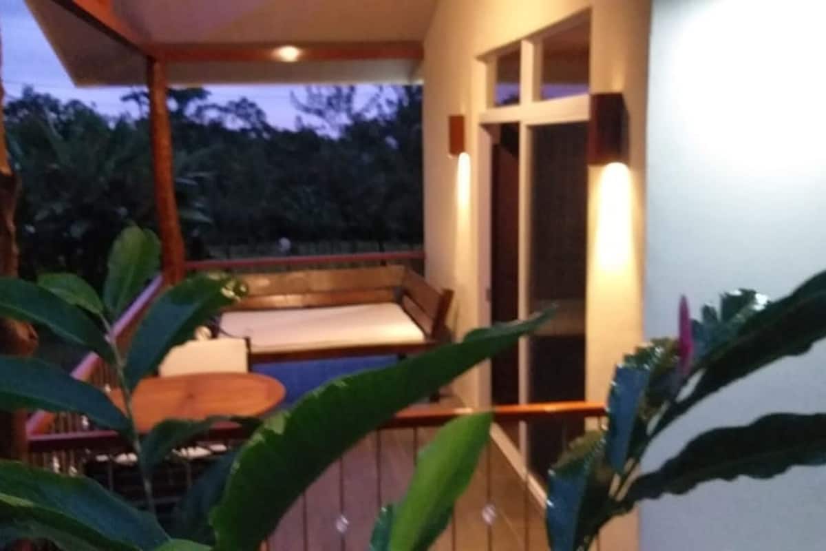 A balcony with a wooden railing, a small table, and a bench.