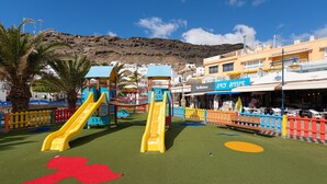 Un parque infantil con dos toboganes y una zona de juegos roja y azul.