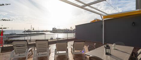 Een terras met uitzicht op de haven, inclusief boten en gebouwen in de verte.