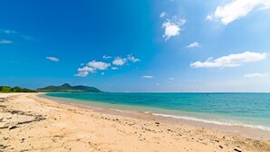 Una playa con aguas azules cristalinas y una orilla arenosa.