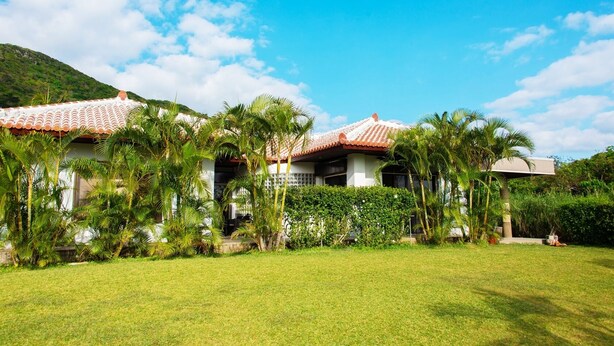 Un resort con varias construcciones, abundante vegetación y un cielo azul despejado.