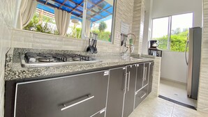 A kitchen with a gas stove, stainless steel sink, and modern cabinetry. - 🏅 Mediterranean Beach Style Villa with Private Pool & Jacuzzi (Tocaima)