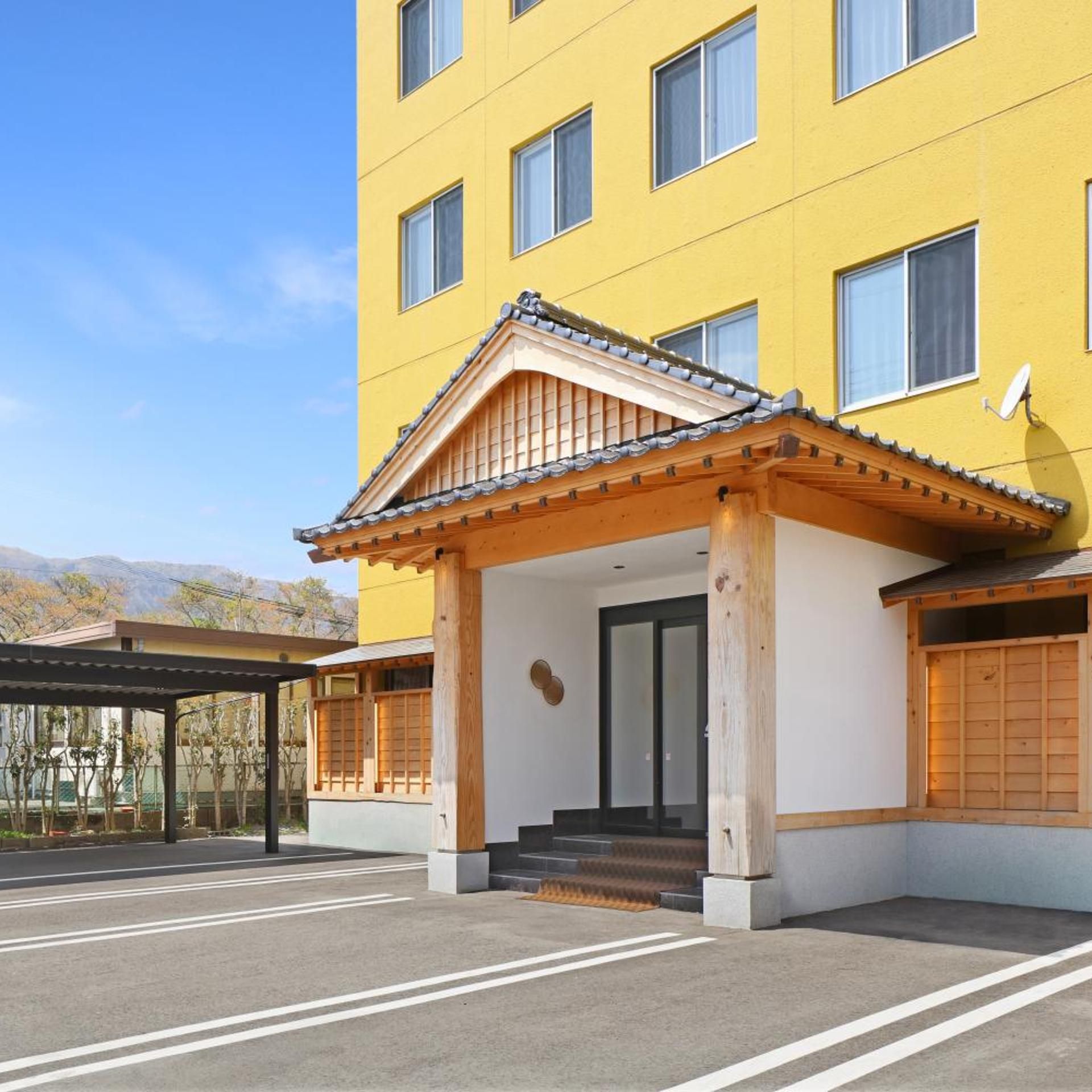 A yellow building with a traditional wooden entrance and a covered walkway.