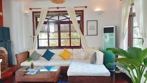 A cozy living room with a sofa, a coffee table, and a potted plant. - Sun Villa (Nam Nha Trang)