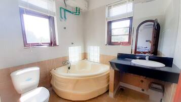 A bathroom with a toilet, a bathtub, and a sink.