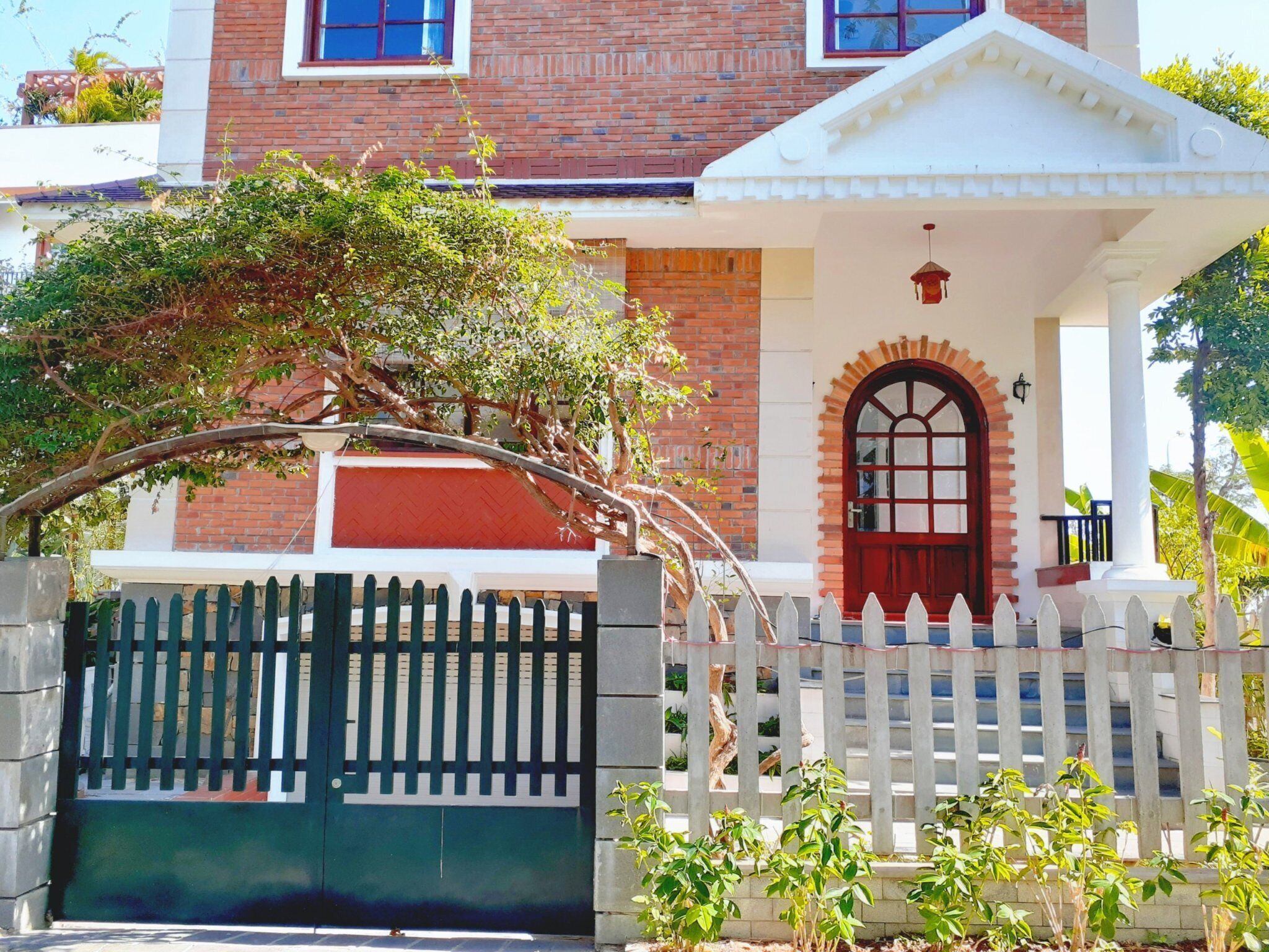 A two-story building with a red door and white porch.