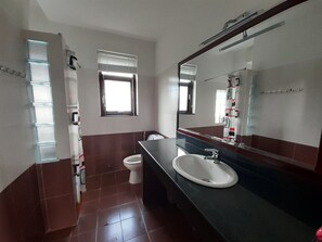 A bathroom with a sink, toilet, and a large mirror. - Sun Villa (Nha Trang)