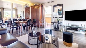 A modern living room with a dining area, a TV, and a fireplace. - Les Patios by Interhome (Saint-Tropez)