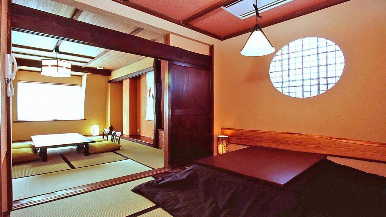 A traditional Japanese room with tatami flooring, a low table, and a shoji screen door.