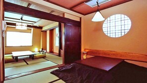 A traditional Japanese room with tatami flooring, a low table, and a shoji screen door. - Sawaemon (Chino)