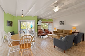 Relax in this inviting living area with a high ceiling, round dining table, and comfortable seating for a cozy gathering.