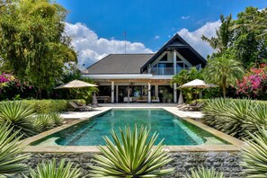 Una piscina al aire libre, tumbonas