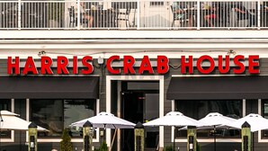 Un restaurante llamado Harris Crab House con terraza y sombrillas.