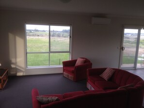 Relax in this inviting living room with a sofa, table, and chair, and enjoy the view from the window.