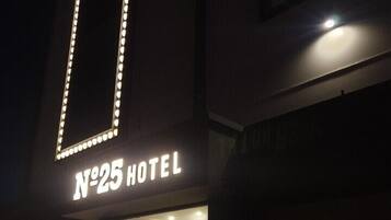 The exterior of a hotel with illuminated signage reading "N°25 HOTEL".