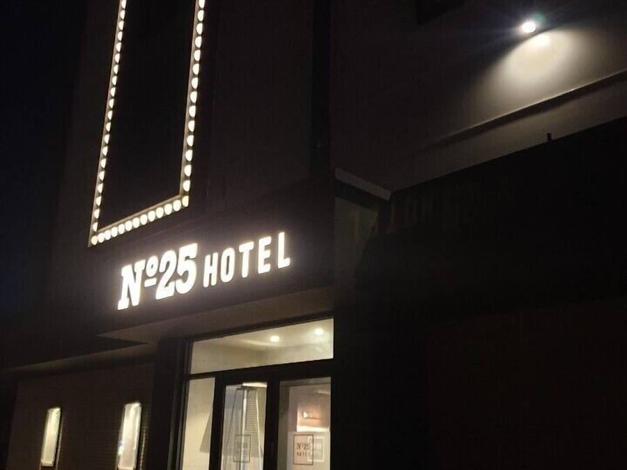 The exterior of a hotel with illuminated signage reading "N°25 HOTEL".