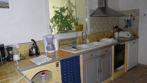 A kitchen with a sink, stove, and various appliances. - The bay house with heated indoor pool (Saint-Jean-du-Doigt)