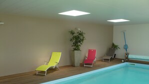 An indoor swimming pool with three lounge chairs and a mop on the right side. - The bay house with heated indoor pool (Saint-Jean-du-Doigt)
