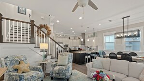 A spacious living area with a staircase, a kitchen, and a dining area. - Three Times The Fun by AvantStay | Blue Mountain | Pool + Pet-Friendly (Santa Rosa Beach)
