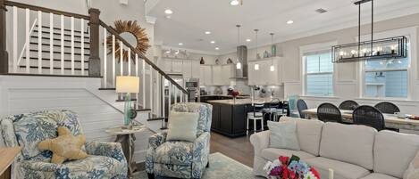 A spacious living area with a staircase, a kitchen, and a dining area.
