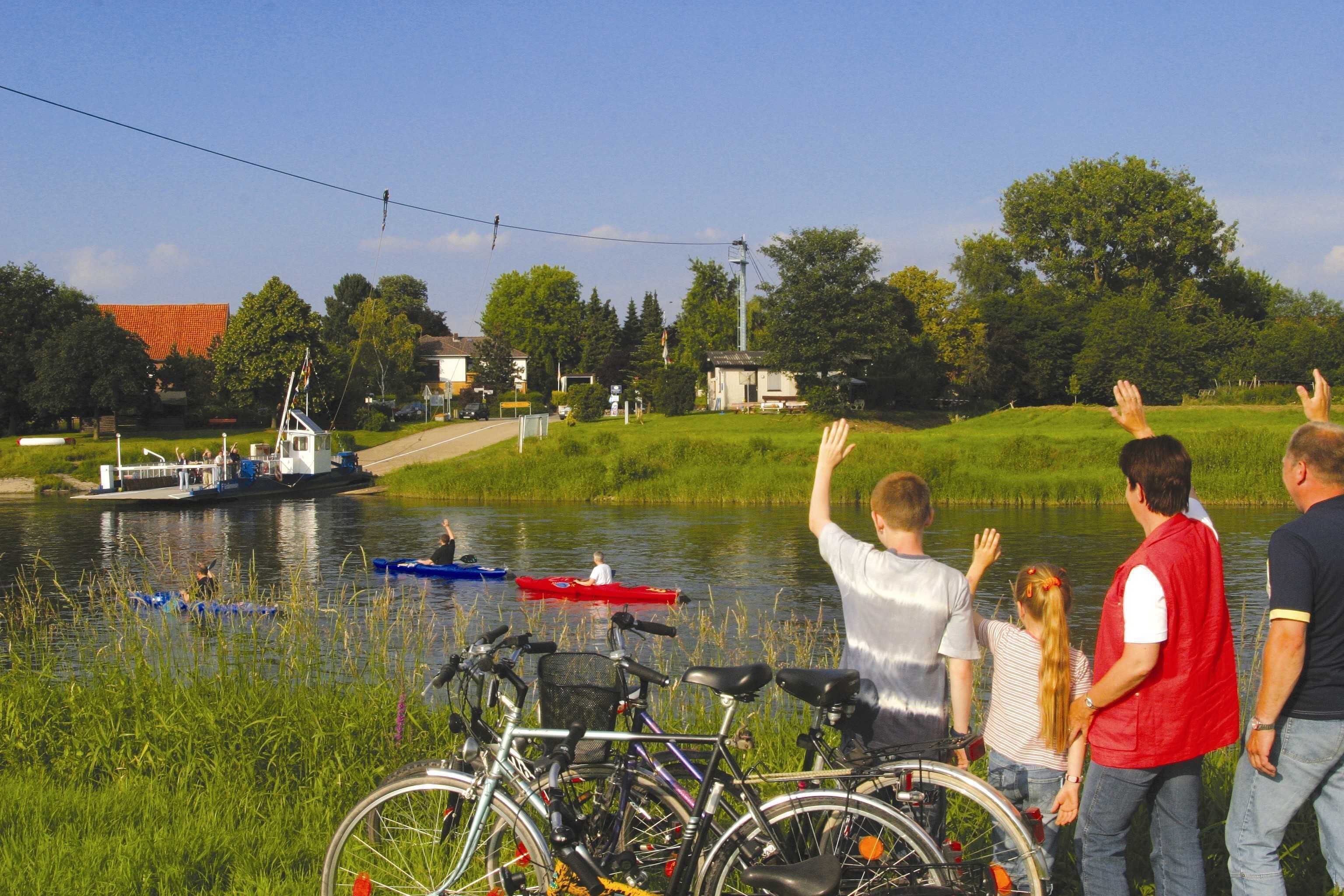 A lakeside view with boats, bicycles, and people by the water.