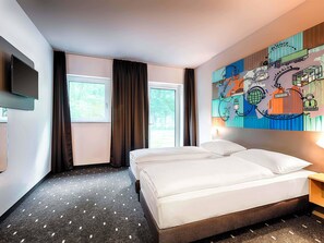 A hotel room with two beds, a flat-screen TV, a large window, and a colorful wall mural. - B&B Hotel Stuttgart-Neckarhafen (Stuttgart)