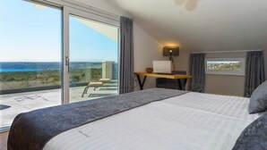 A bedroom with a large bed, a desk with a lamp, and a view of the sea. - Villa A.R.T. Viskovici (Koromačno)