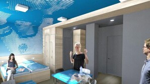 Quarto de hotel moderno com cama, escrivaninha e área de estar.
