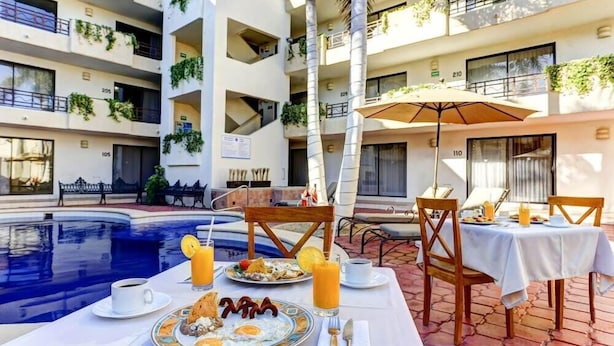 Ein Frühstückstisch mit Stühlen am Pool.