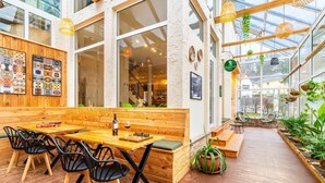 A cozy café with wooden furniture, a chessboard, and a green plant.