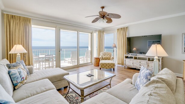 A spacious living room with a large TV, comfortable seating, and a balcony with a view of the ocean. - Grand Surf 7W! PCB Most Prestigious Address. Huge Condo, Exceptional. (Panama City Beach)
