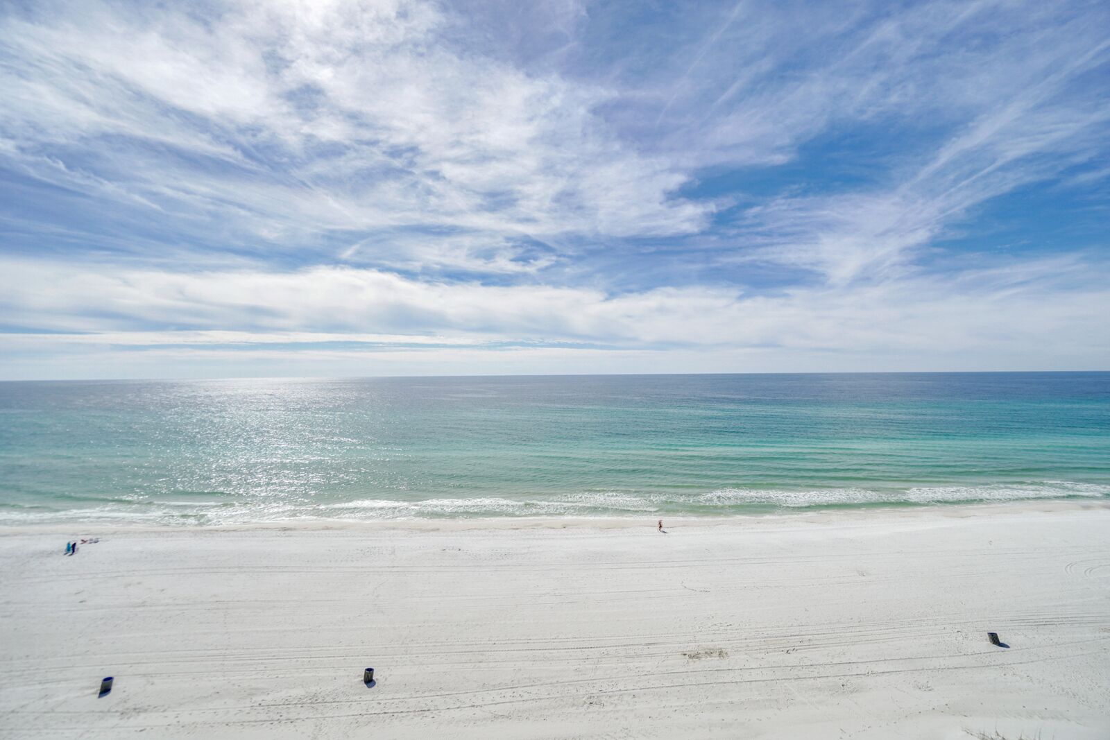 A beach with a wide sandy shore and calm ocean.