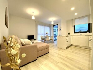 A modern apartment with a living room, dining area, and kitchen.