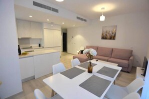 Un appartement moderne comprenant un coin repas, une cuisine et un salon.