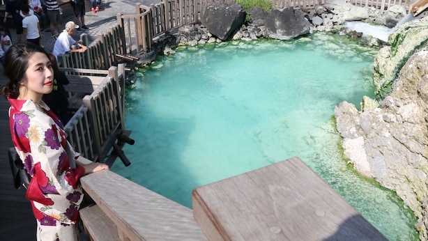 Une piscine aux eaux cristallines, dotée d’une terrasse en bois et entourée d’une clôture en bois.