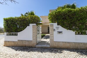 A gated entrance to a building with a stone wall and a sign indicating 'LOTTE.'
