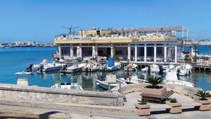 A marina with boats docked in front of a building with a balcony.