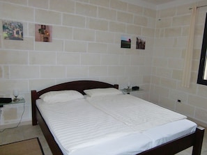 A bedroom with a large bed, two bedside tables, and a wall-mounted shelf. - VILLA AMICORUM House WEST, 10 x 4 m pool (San Pietro In Bevagna)