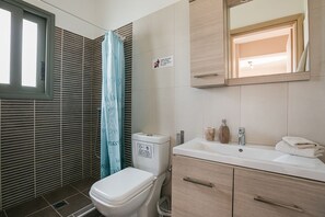 A modern bathroom with a toilet, sink, and shower.