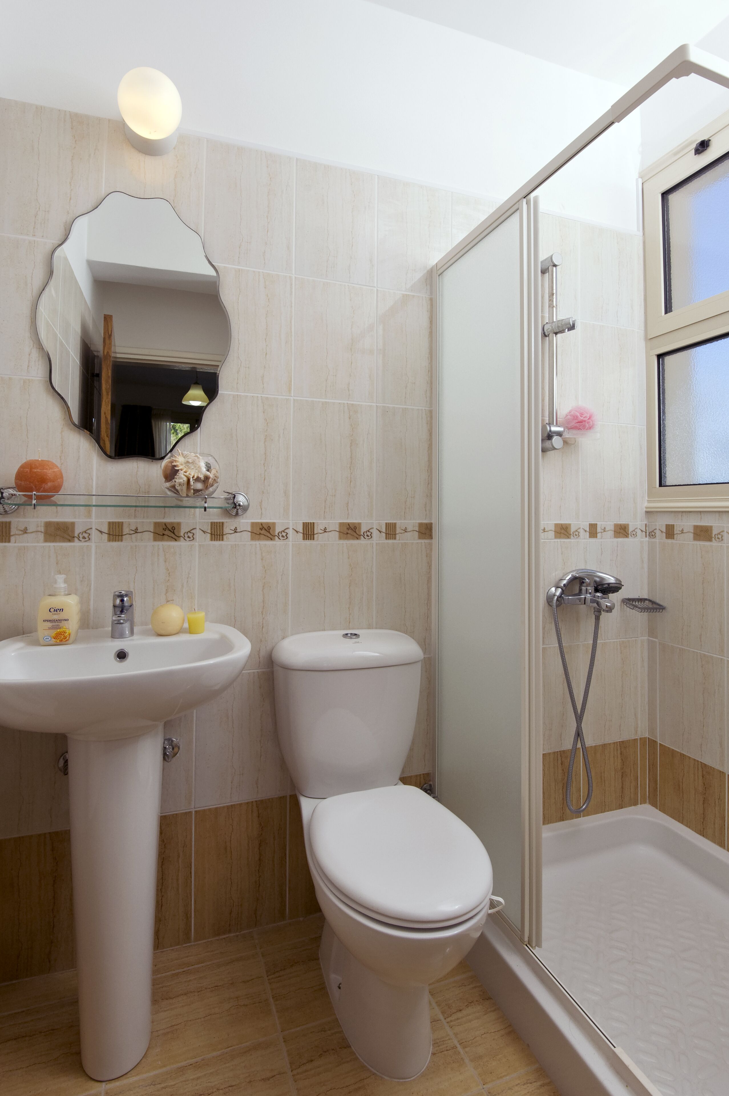 A bathroom with a sink, toilet, and a glass-enclosed shower area.